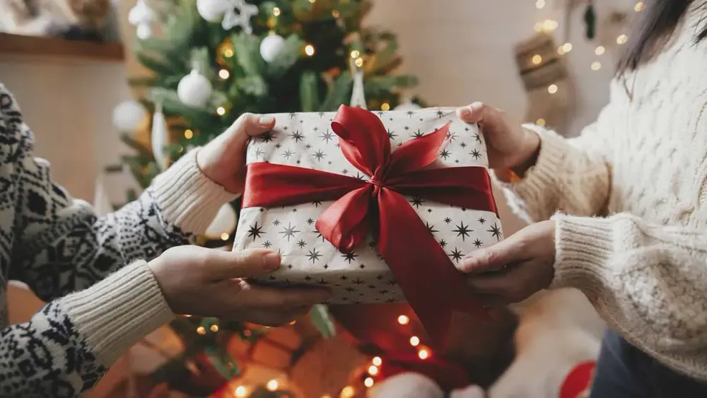 Mamma ger julklapp till barn